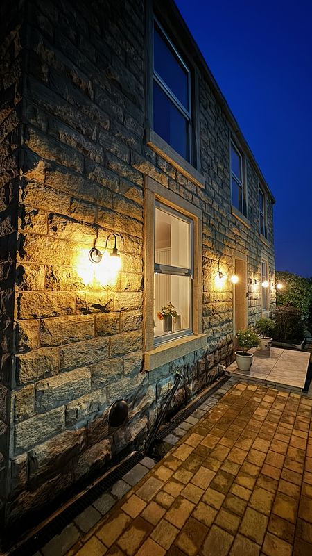 Stone wall at night with brass lights